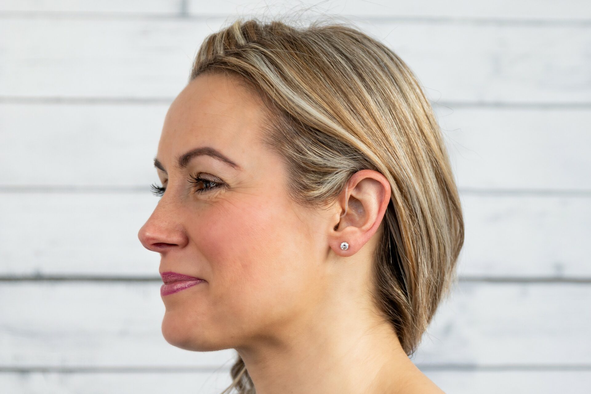 Woman H1 blonde side view - wearing a hearing aid
