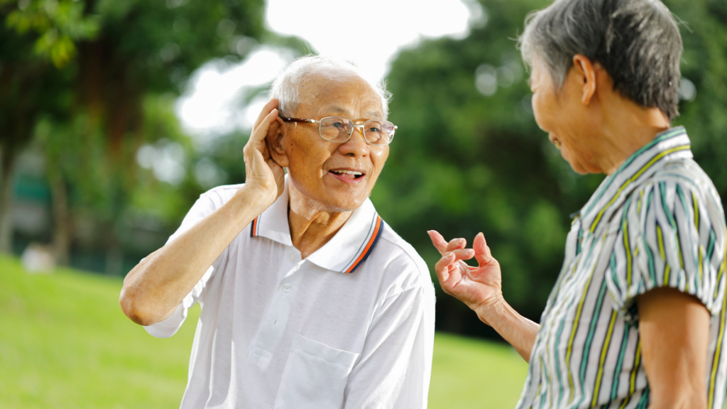 Old man struggling to hear his friend