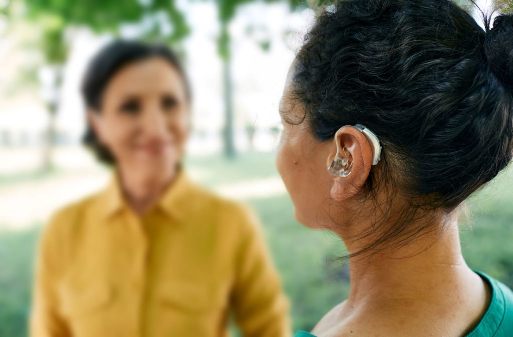 woman wearing a hearing aid in conversation